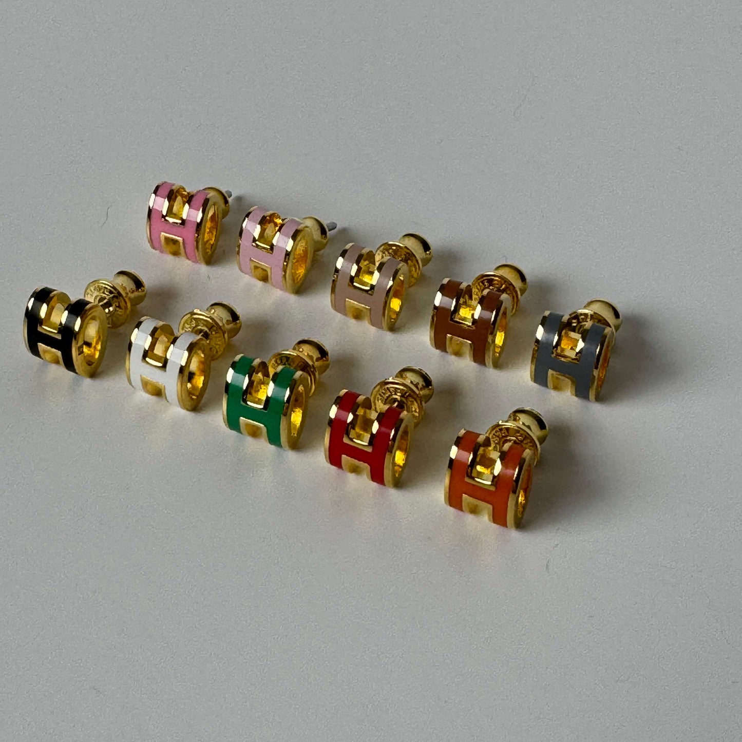 Enamel H stud earrings in yellow gold and white gold finishes