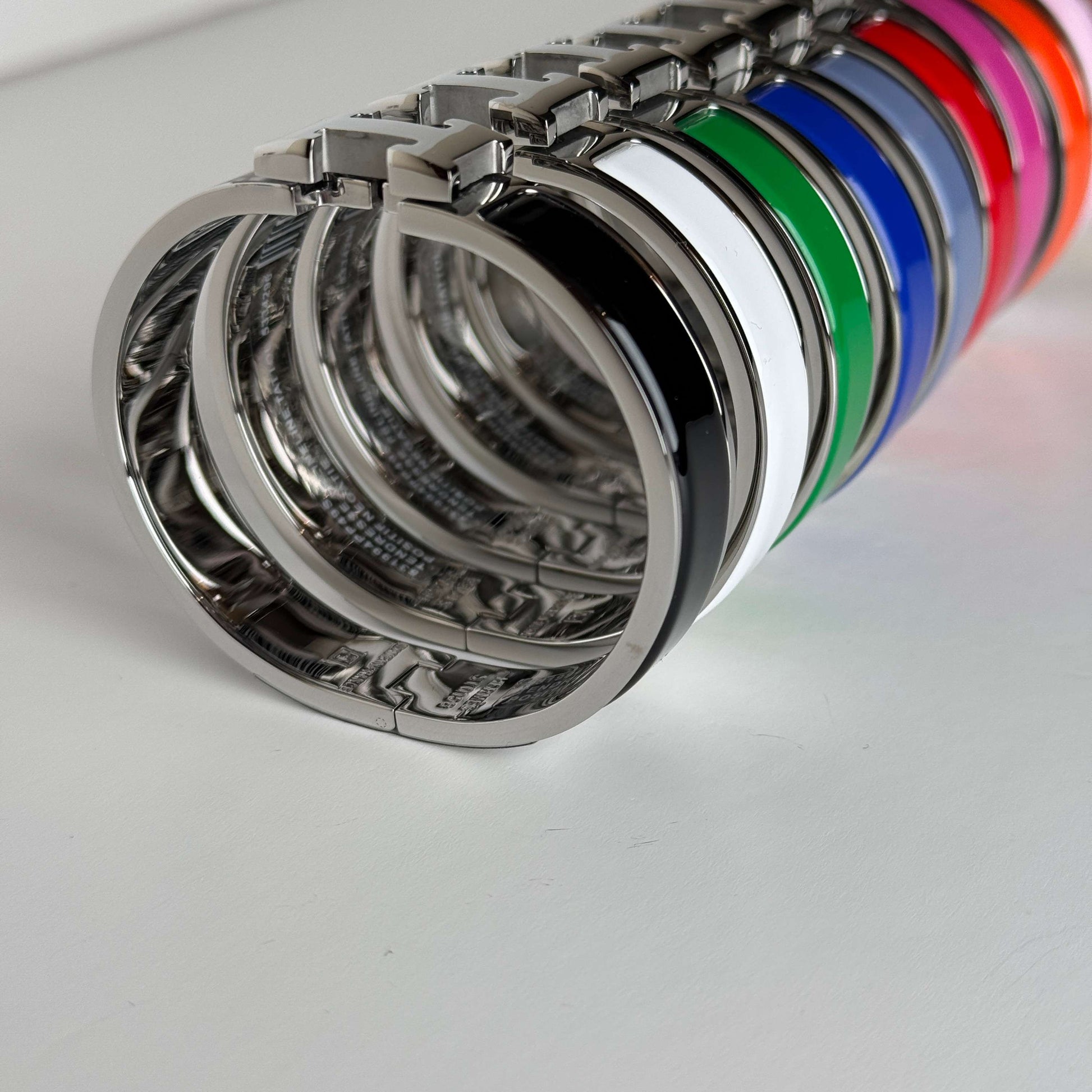 White gold enamel H bangles angled side vie